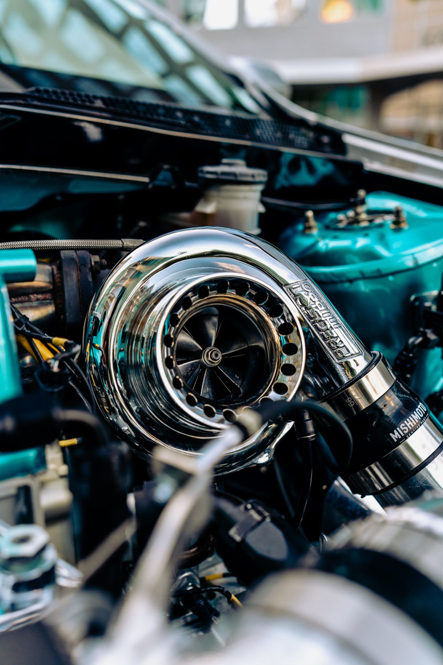 Detailed view of a chrome turbocharger in a car engine showcasing automotive technology.