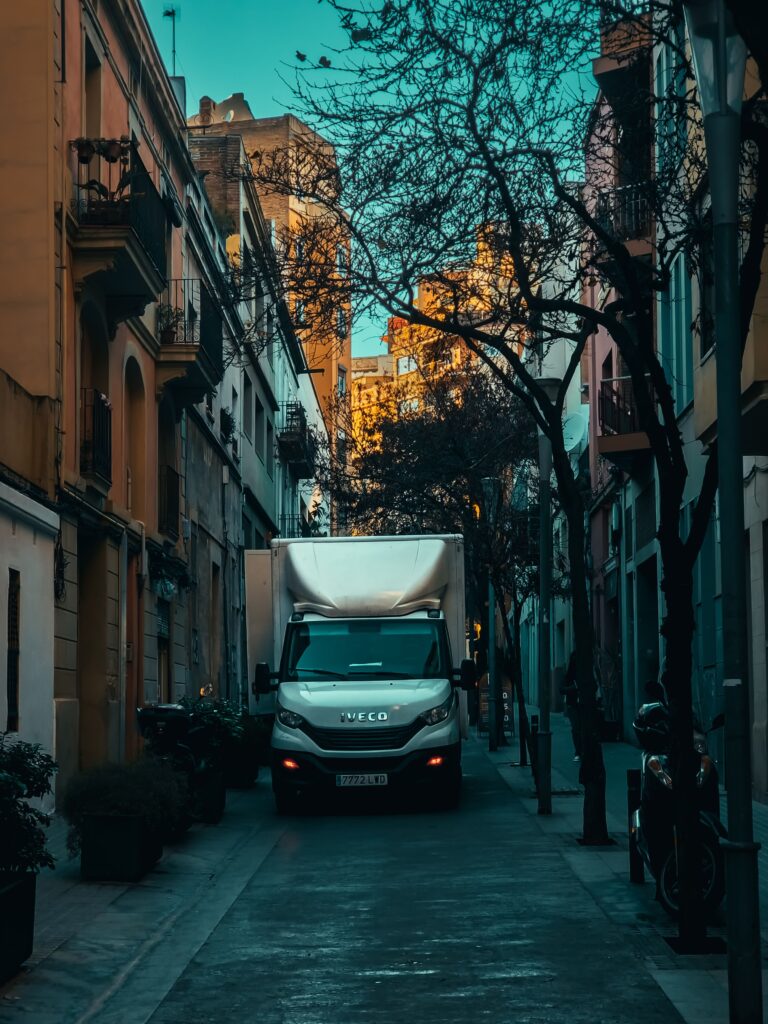 City street scene featuring a truck among urban buildings and trees, captured in a vibrant setting.