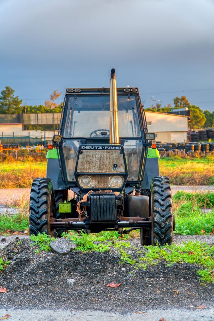 Front view of a classic Deutz-Fahr tractor in Schimatari, Greece, during sunrise with industrial background.