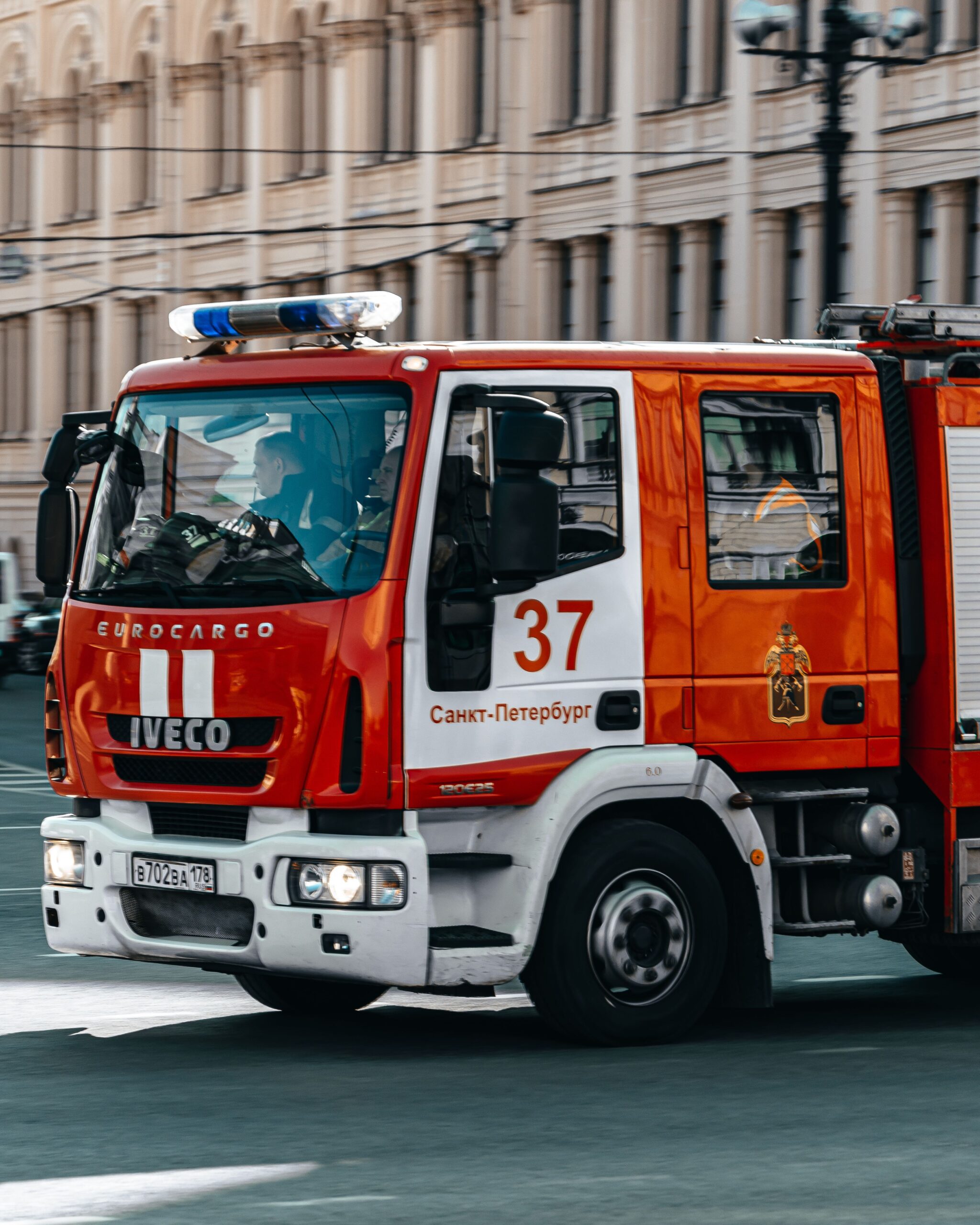 A bright red fire truck on duty in a bustling street of Saint Petersburg, Russia.